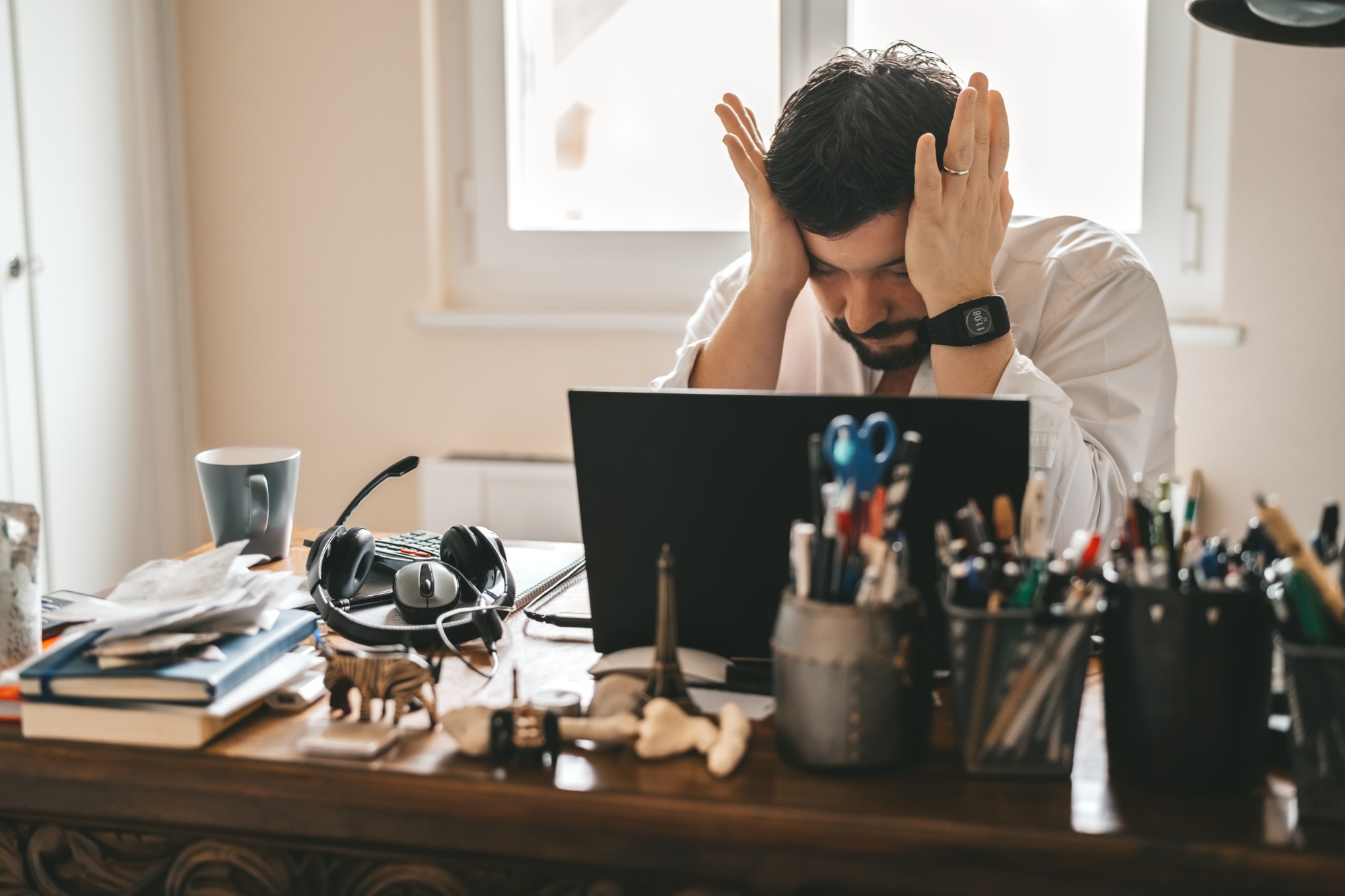 man with hands at head frustrated at work leadership